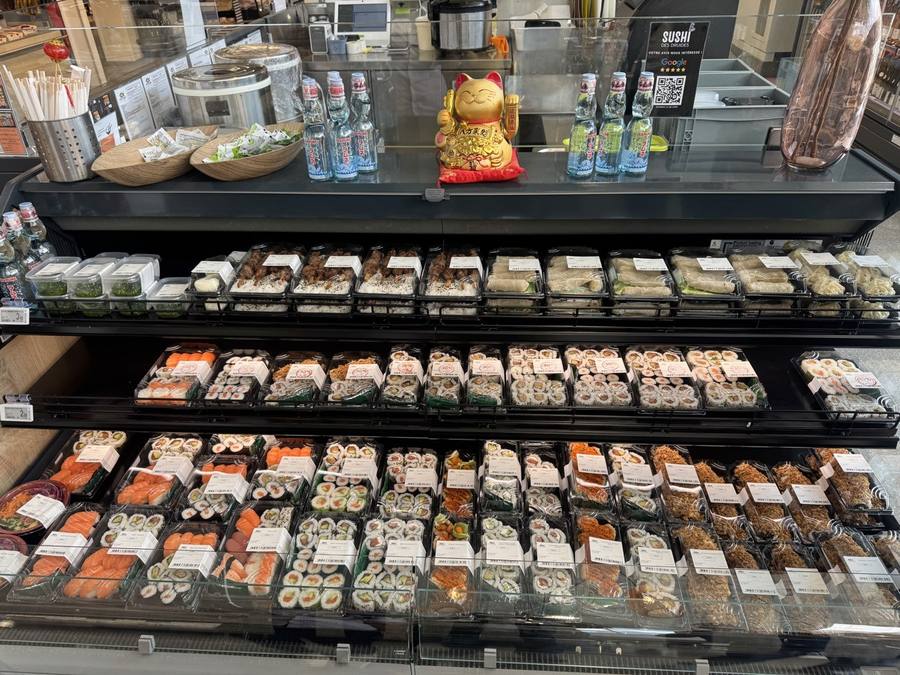 La vitrine réfrigérée garnie de barquettes de sushis et makis frais